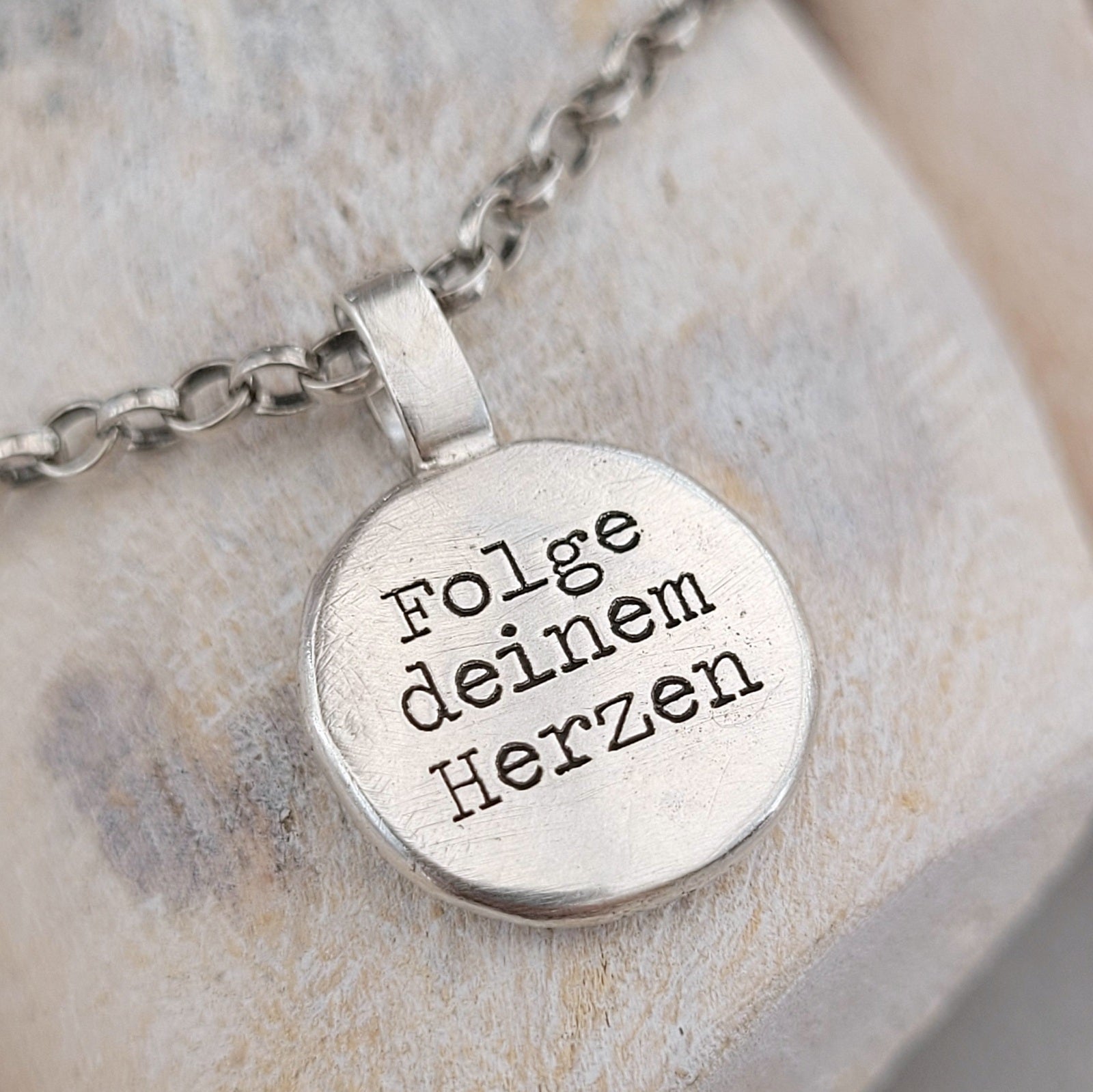 Anhänger Nugget mit Gravur "Kompass mit Herz" und "Folge deinem Herzen". Jedes Schmuckstück ist ein Unikat. Der handgefertigte Anhänger aus recyceltem Silber zeigt auf der Vorderseite einen gravierten Kompass mit Herz. Zusätzlich kannst du einen Text als Gravur auf der Rückseite wählen. Kein Anhänger gleicht exakt dem anderen und ist dein personalisiertes Unikat. Von animoART