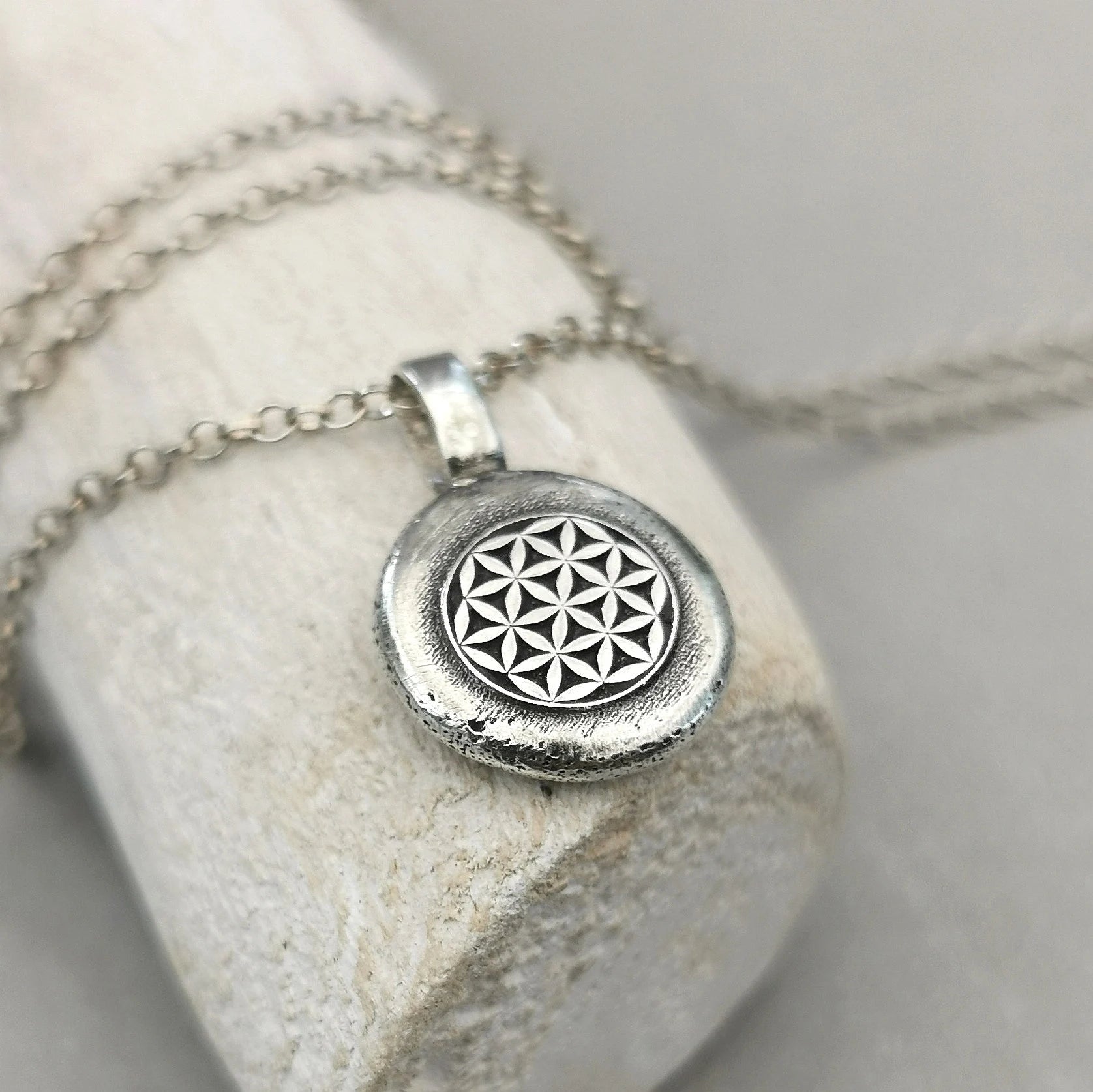 Lebensblume - Anhänger mit Gravur Aus der Kollektion Nuggets Motiv "Lebensblume" Jedes Schmuckstück ist ein handgefertigtes Unikat. Der Anhänger mit Lebensblume aus recyceltem Silber zeigt eine plastische Blume des Lebens. Kein Anhänger gleicht exakt dem anderen und jeder ist ein persönliches Unikat. Zusätzlich kannst du einen Text als Gravur für die Rückseite wählen.