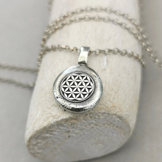 Lebensblume - Anhänger mit Gravur Aus der Kollektion Nuggets Motiv "Lebensblume" Jedes Schmuckstück ist ein handgefertigtes Unikat. Der Anhänger mit Lebensblume aus recyceltem Silber zeigt eine plastische Blume des Lebens. Kein Anhänger gleicht exakt dem anderen und jeder ist ein persönliches Unikat. Zusätzlich kannst du einen Text als Gravur für die Rückseite wählen.