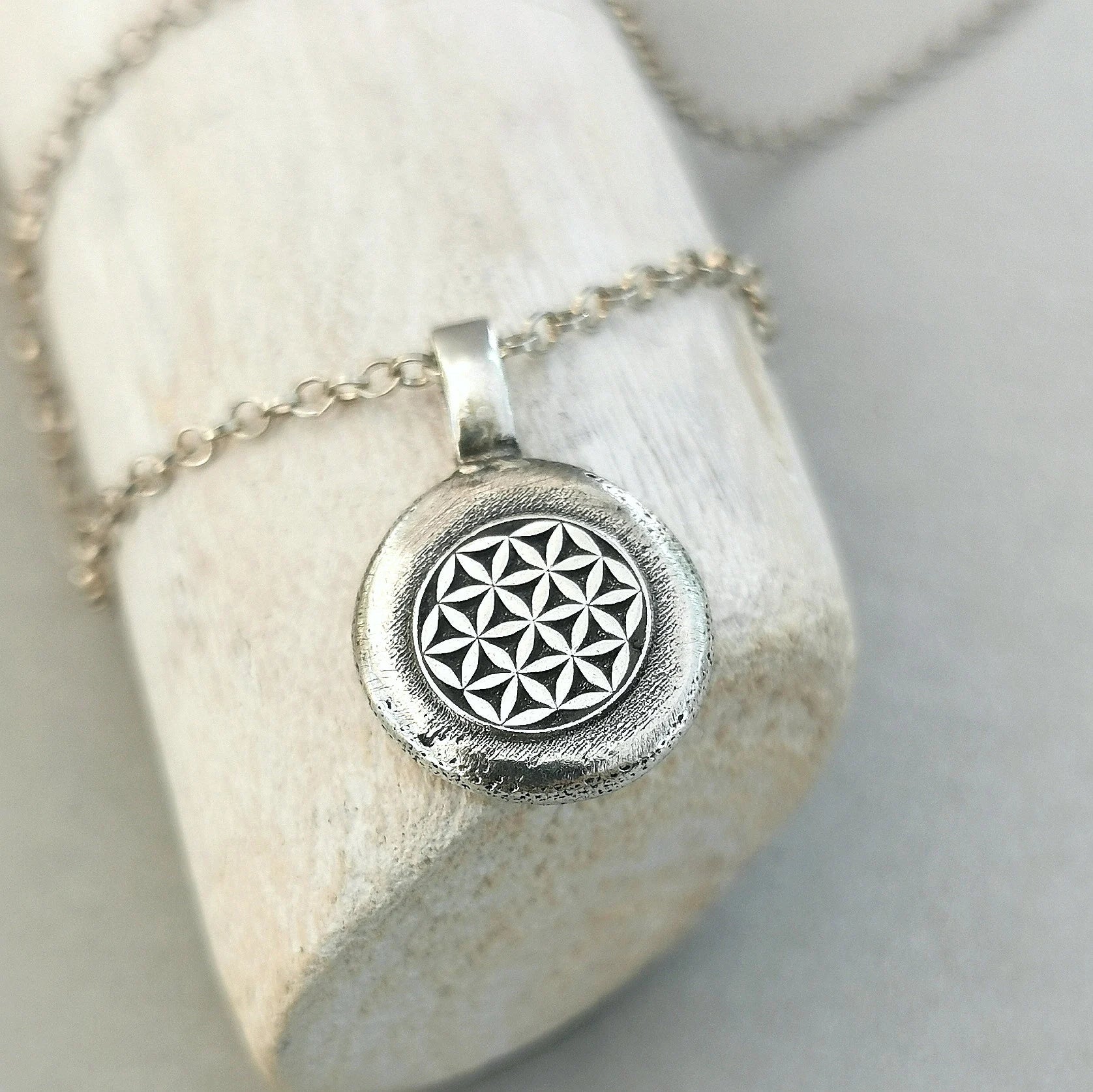 Lebensblume - Anhänger mit Gravur Aus der Kollektion Nuggets Motiv "Lebensblume" Jedes Schmuckstück ist ein handgefertigtes Unikat. Der Anhänger mit Lebensblume aus recyceltem Silber zeigt eine plastische Blume des Lebens. Kein Anhänger gleicht exakt dem anderen und jeder ist ein persönliches Unikat. Zusätzlich kannst du einen Text als Gravur für die Rückseite wählen.