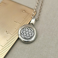 Lebensblume - Anhänger mit Gravur Aus der Kollektion Nuggets Motiv "Lebensblume" Jedes Schmuckstück ist ein handgefertigtes Unikat. Der Anhänger mit Lebensblume aus recyceltem Silber zeigt eine plastische Blume des Lebens. Kein Anhänger gleicht exakt dem anderen und jeder ist ein persönliches Unikat. Zusätzlich kannst du einen Text als Gravur für die Rückseite wählen.