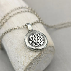 Lebensblume - Anhänger mit Gravur Aus der Kollektion Nuggets Motiv "Lebensblume" Jedes Schmuckstück ist ein handgefertigtes Unikat. Der Anhänger mit Lebensblume aus recyceltem Silber zeigt eine plastische Blume des Lebens. Kein Anhänger gleicht exakt dem anderen und jeder ist ein persönliches Unikat. Zusätzlich kannst du einen Text als Gravur für die Rückseite wählen.