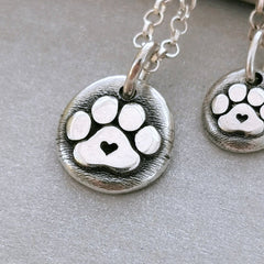 Der plastische Hundepfoten - Anhänger mit Herz ist ein Unikat aus recyceltem Sterlingsilber und wird speziell für dich handgefertigt. Ein Geschenk von Herzen für alle Pfoten - Liebhaber! Wähle den Anhänger ohne Kette, mit Silberkette oder Lederkette.