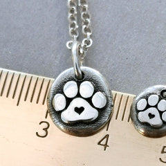 Der plastische Hundepfoten - Anhänger mit Herz ist ein Unikat aus recyceltem Sterlingsilber und wird speziell für dich handgefertigt. Ein Geschenk von Herzen für alle Pfoten - Liebhaber! Wähle den Anhänger ohne Kette, mit Silberkette oder Lederkette.