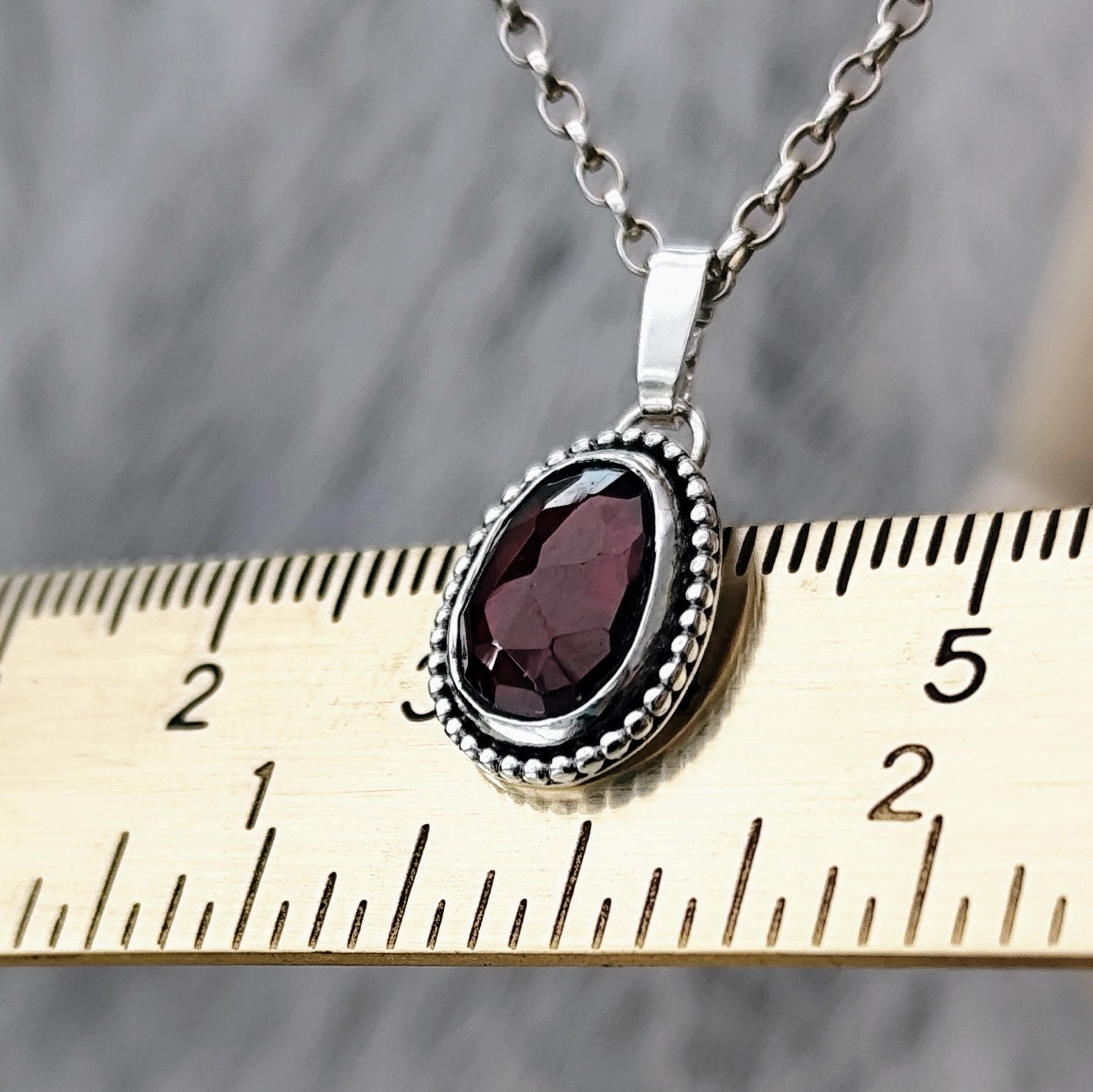 handgefertigter Kettenanhänger aus recyceltem Silber mit Granat und individueller Gravur.