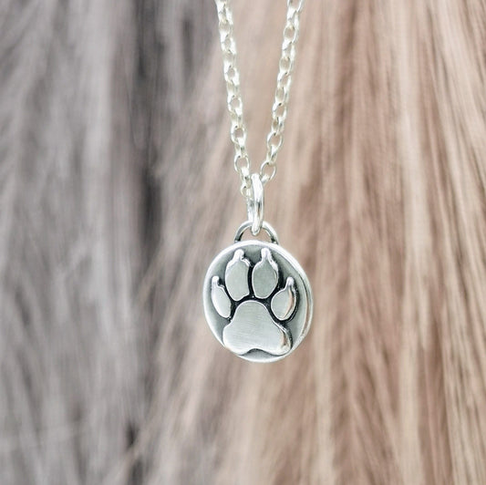 Handgefertigter Kettenanhänger aus recyceltem 925er Silber in Form einer Hundepfote, Symbol für die Liebe zu Haustieren, personalisierbar mit Gravur.