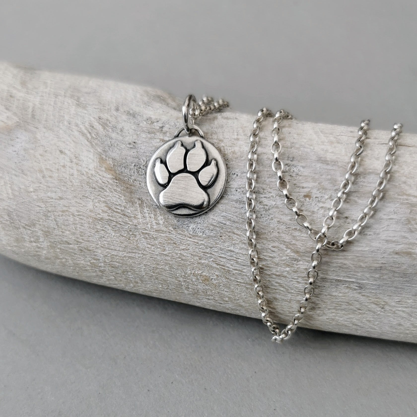 Kettenanhänger Hundepfote, handgefertigt aus recyceltem 925er Silber, symbolisiert Tierliebe, personalisierbar mit Gravur, nachhaltig in Deutschland gefertigt.