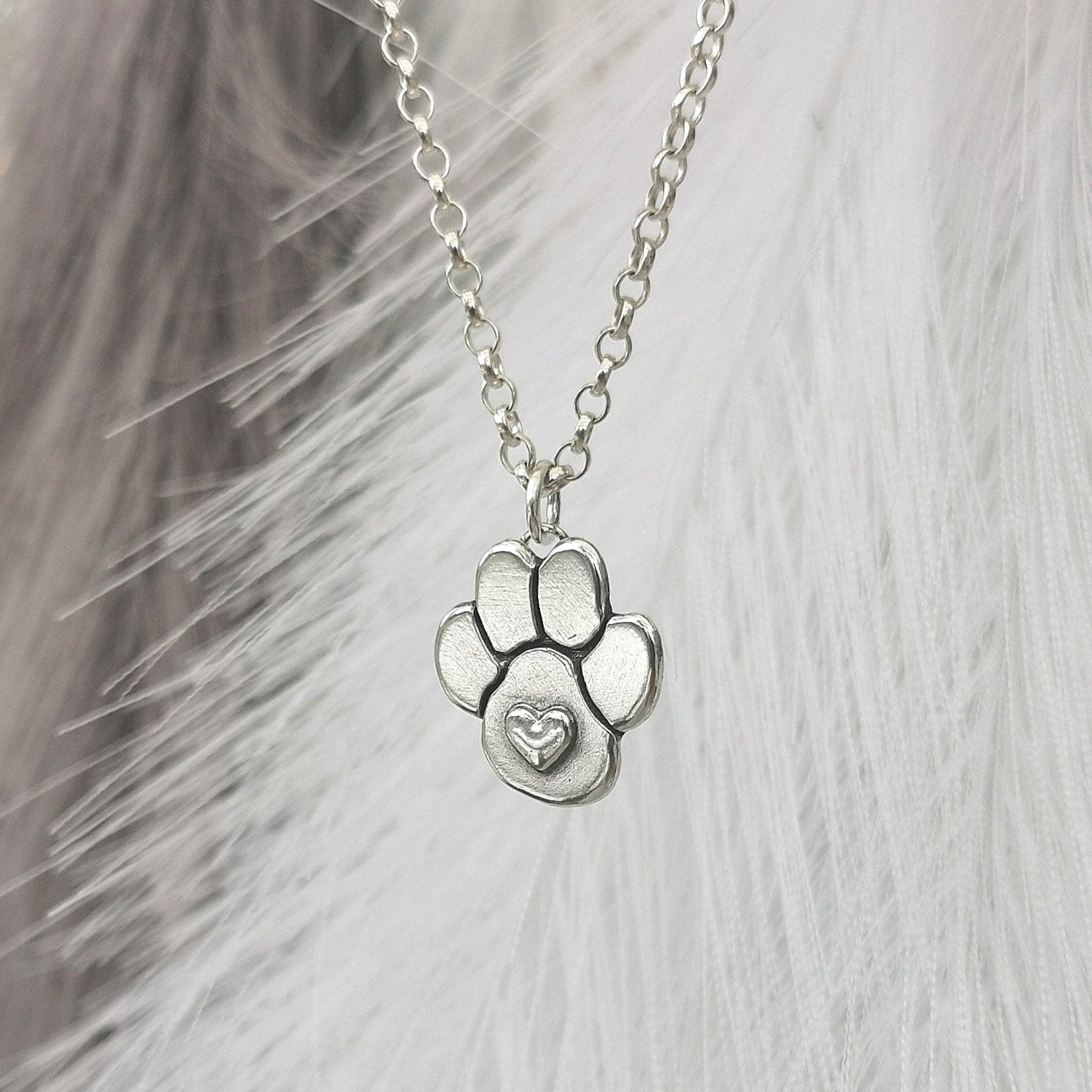 Nachhaltiger Kettenanhänger in Form einer Hundepfote mit Herz, gefertigt aus recyceltem Silber, handgefertigtes Symbol für Tierliebe, personalisierbar mit Gravur.