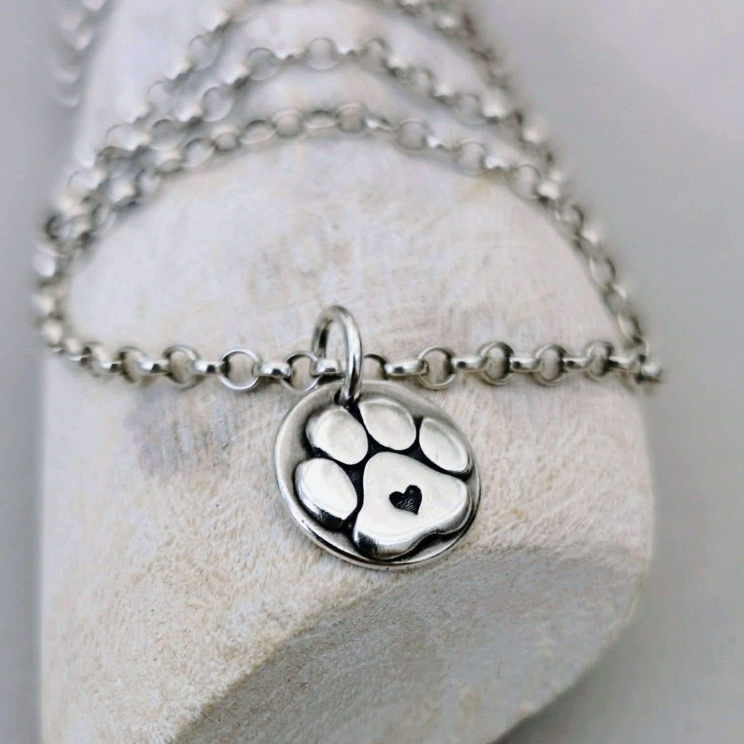 Handgefertigter Kettennhänger aus recyceltem 925er Silber in Form einer Hundepfote mit Herz, Symbol für Pfotenliebe, personalisierbar mit Gravur."