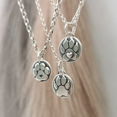 Handgefertigter Hundepfoten-Anhänger aus recyceltem Silber, symbolisiert die Liebe zu Tieren, personalisierbar mit Gravur, nachhaltig hergestellt.