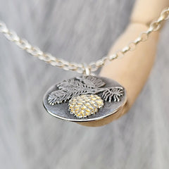 Handgefertigter Kettenanhänger „Tannenzapfen“ aus recyceltem 925er Sterlingsilber mit Teilvergoldung in 24 Karat Gelbgold. Symbol für Transformation, Geduld und inneres Wachstum – nachhaltiger Schmuck mit Bedeutung, aus Deutschland.