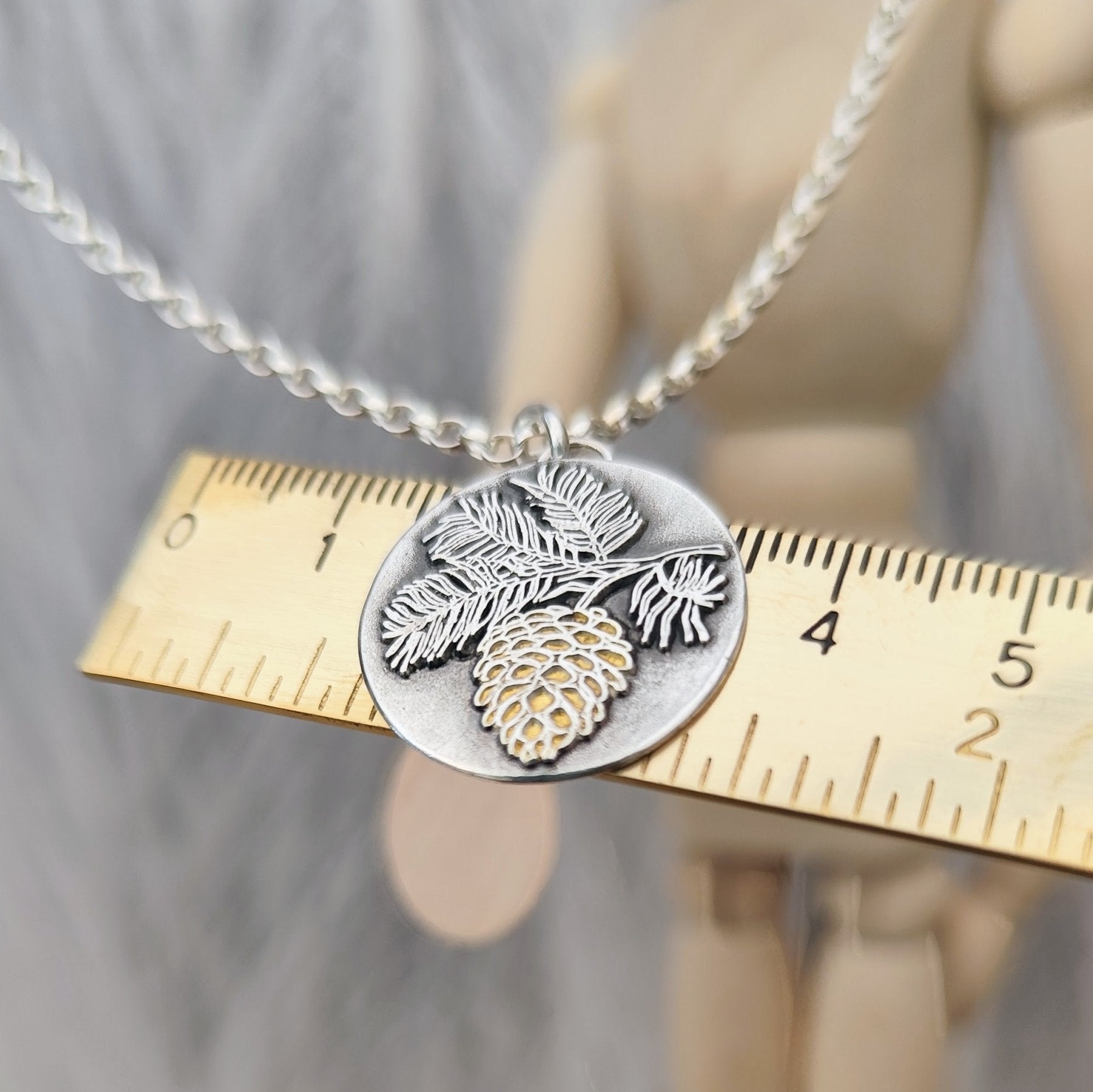 Handgefertigter Kettenanhänger „Tannenzapfen“ aus recyceltem 925er Sterlingsilber mit Teilvergoldung in 24 Karat Gelbgold. Symbol für Transformation, Geduld und inneres Wachstum – nachhaltiger Schmuck mit Bedeutung, aus Deutschland.