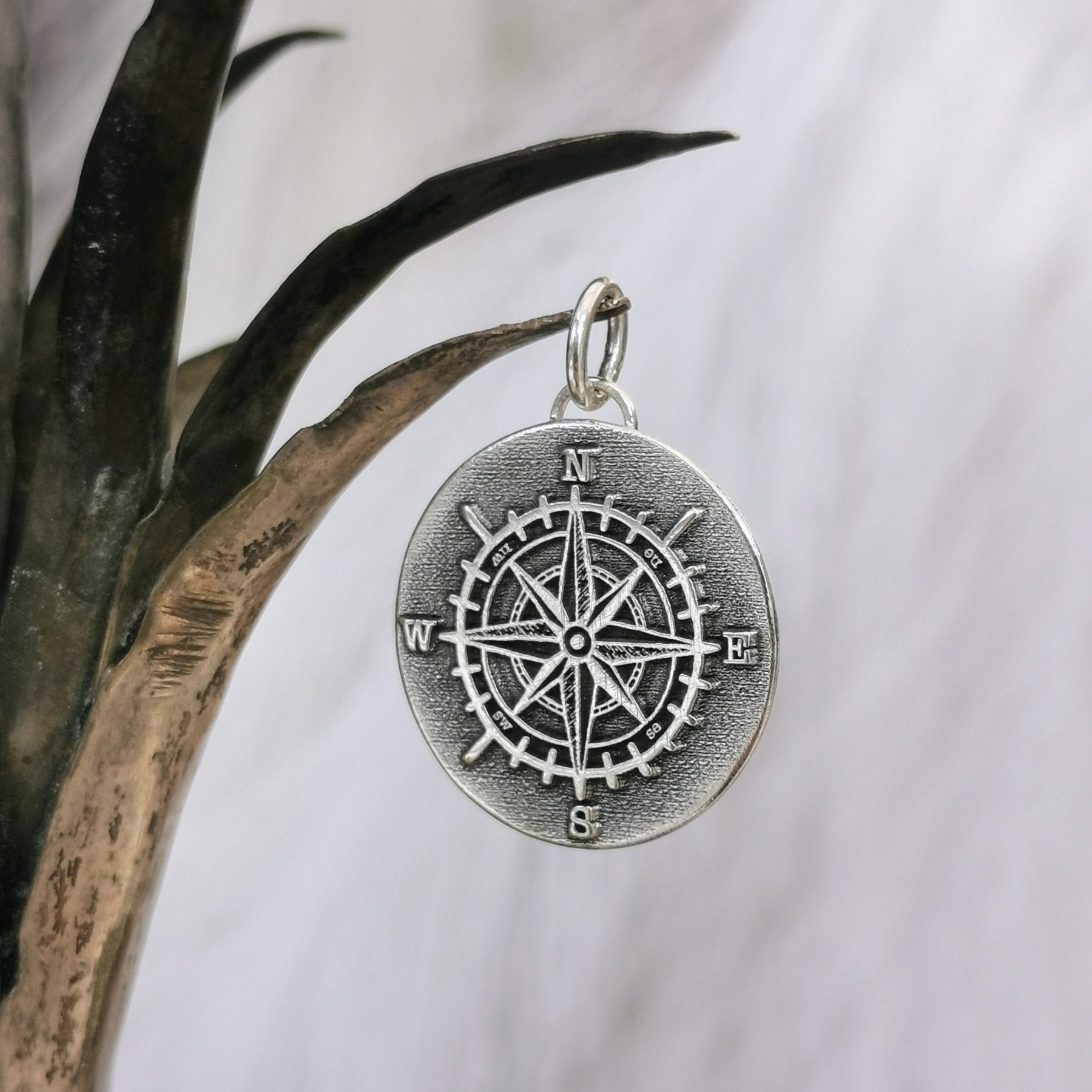 Handgefertigter Kettenanhänger aus recyceltem 925er Silber in Form eines Kompasses, Symbol für Orientierung und Navigation, personalisierbar mit Gravur.