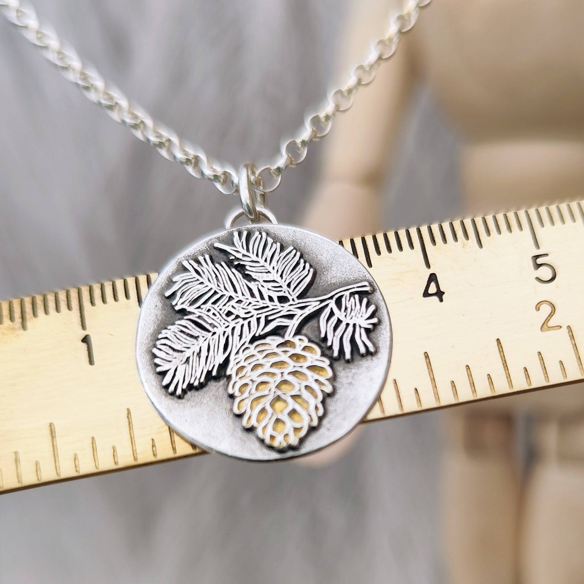 Schmuckanhänger Tannenzapfen aus 925er recyceltem Silber mit vergoldeter Oberfläche, inspiriert von der Weisheit des Waldes. Für Naturliebhaber*innen, handgemacht in Deutschland – optional mit Kette erhältlich.