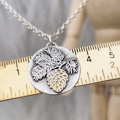 Schmuckanhänger Tannenzapfen aus 925er recyceltem Silber mit vergoldeter Oberfläche, inspiriert von der Weisheit des Waldes. Für Naturliebhaber*innen, handgemacht in Deutschland – optional mit Kette erhältlich.