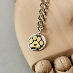 Handgefertigter Kettenanhänger aus recyceltem Silber, vergoldete Hundepfote mit Herz, Symbol für Pfotenliebe, personalisierbar mit Gravur.