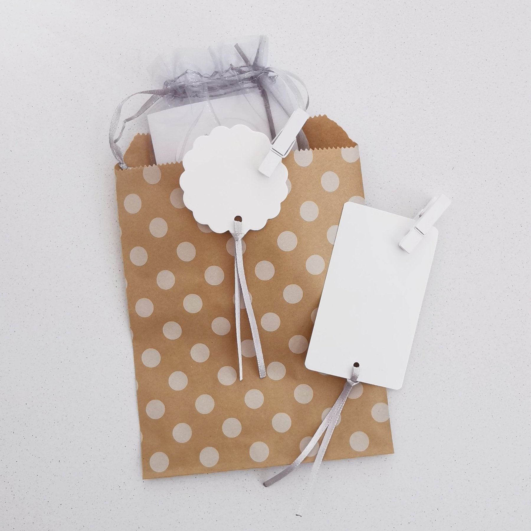 Geschenktüte aus Papier mit Namensschild, Schleifband & kleiner Holzklammer. Dazu gibt´s einen lustigen Geschenkanhänger.