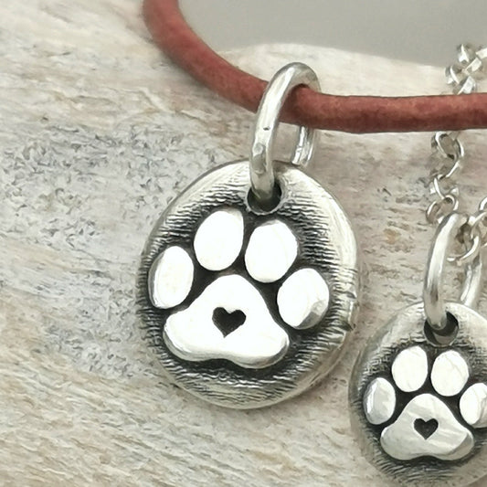 Der plastische Hundepfoten - Anhänger mit Herz ist ein Unikat aus recyceltem Sterlingsilber und wird speziell für dich handgefertigt. Ein Geschenk von Herzen für alle Pfoten - Liebhaber! Wähle den Anhänger ohne Kette, mit Silberkette oder Lederkette.