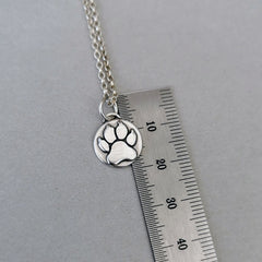 Nachhaltiger Kettenanhänger in Form einer Hundepfote, gefertigt aus recyceltem Silber, handgefertigtes Symbol für Tierliebe, personalisierbar mit Gravur.
