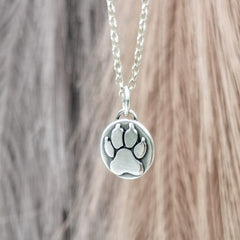 Handgefertigter Kettenanhänger aus recyceltem 925er Silber in Form einer Hundepfote, Symbol für die Liebe zu Haustieren, personalisierbar mit Gravur.
